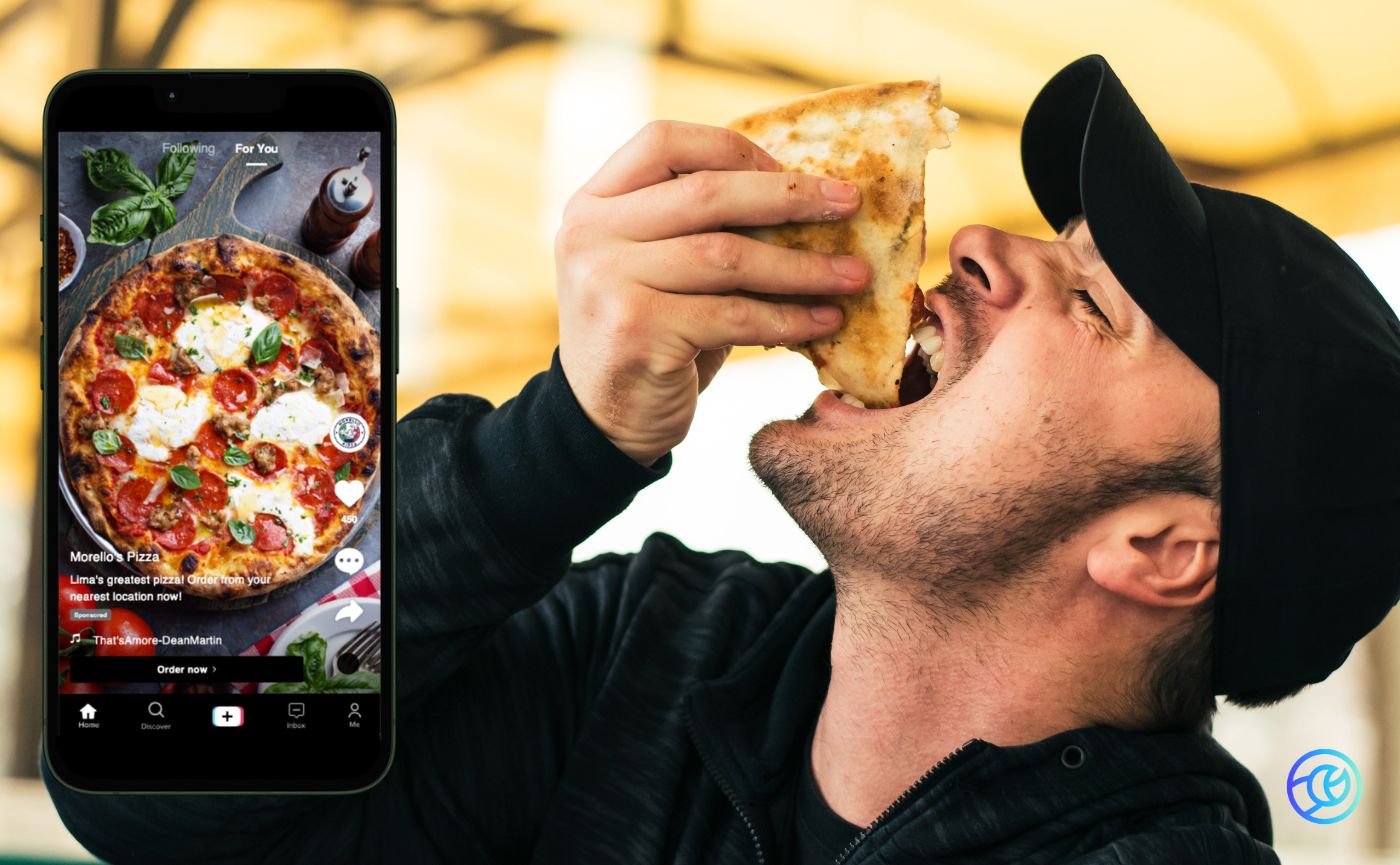 Guy eating food with a phone that has a pizza on the screen