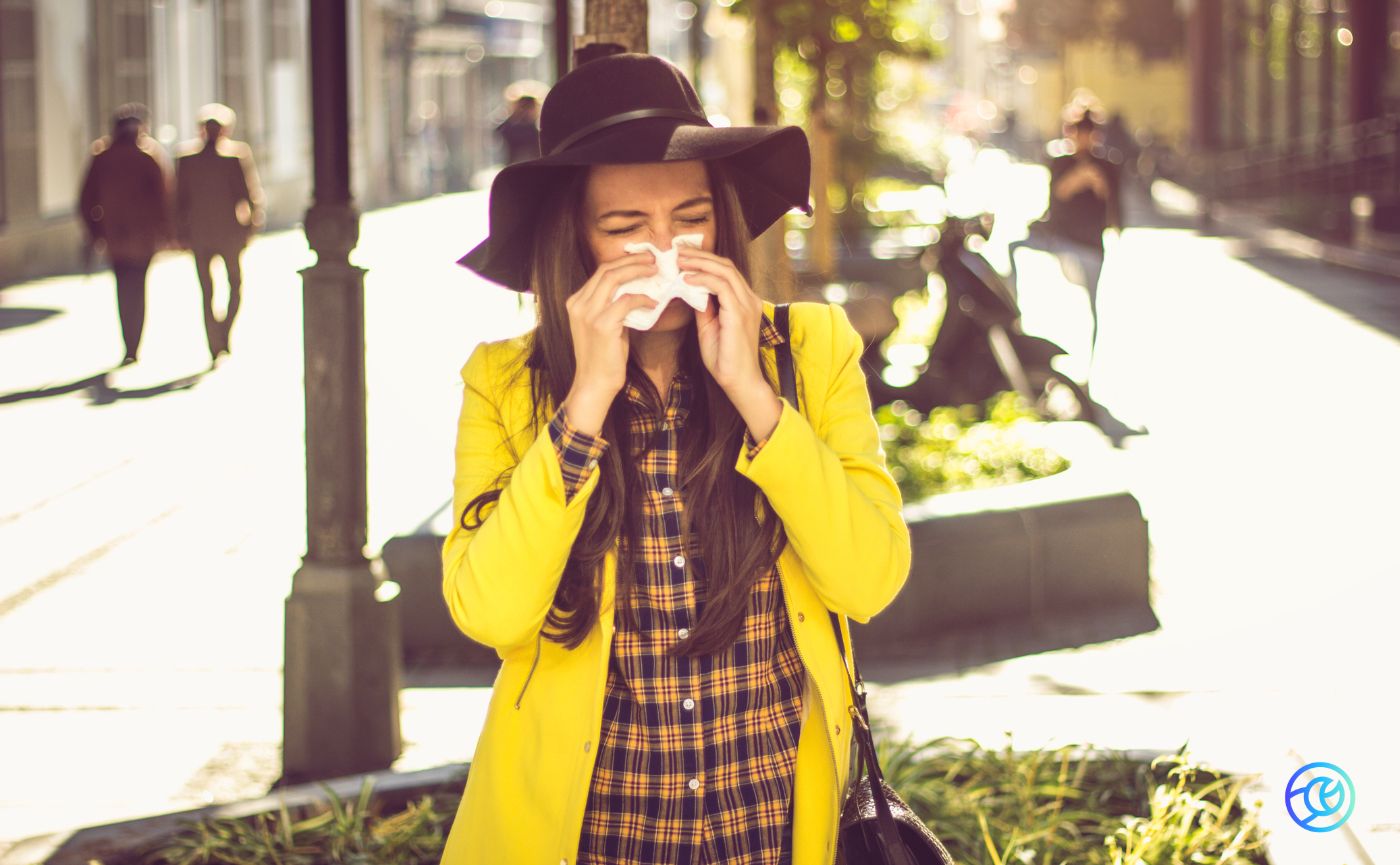 Women in yellow jacked blowing nose into tissue