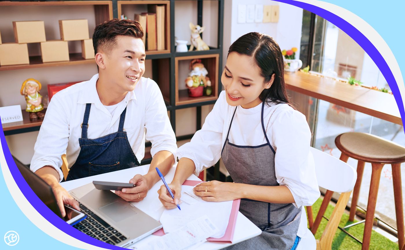 Team members reviewing franchise marketing budget planning documents in a small business setting.